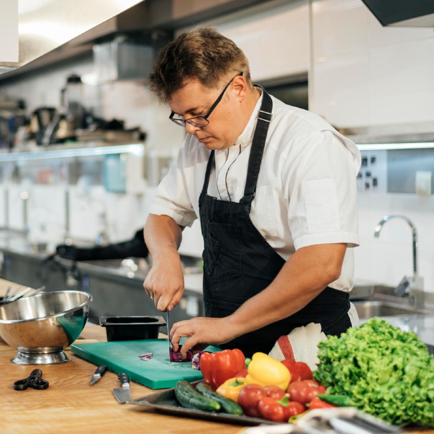 Un cuisinier émince des légumes